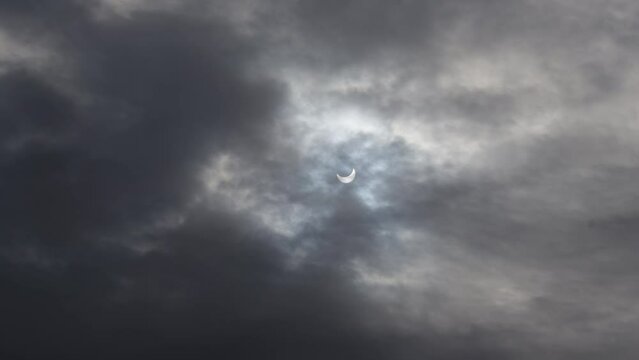 A solar eclipse in cloudy weather through a cloud. partial solar eclipse.