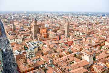 Fototapeta na wymiar Aerial Cityscape view from the tower Asinelli on Bologna old town center with Maggiore square in Italy.Colorful sky over the historical city center with car traffic and old buildings