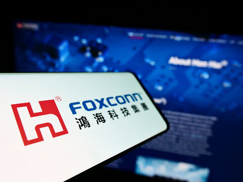 Stuttgart, Germany - 10-21-2022: Smartphone with logo of Hon Hai Precision Industry Co. Ltd. (Foxconn) on screen in front of business website. Focus on left of phone display.