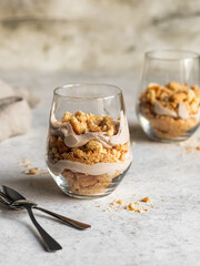 Layered dessert with crushed biscuits and ricotta or cottage cheese in a glass