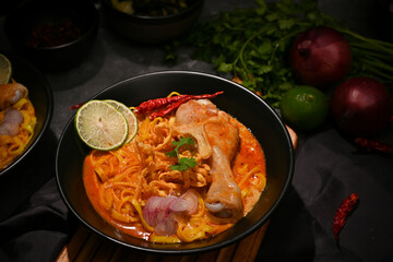 Delicious Khao Soi Kai or Thai curry noodles with chicken drumstick, vegetables