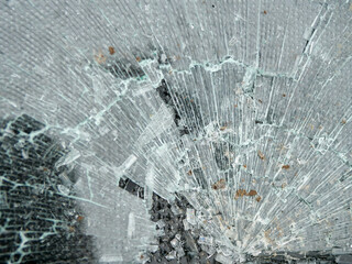Damaged broken glass. Act of vandalism or war conflict. Grey color.