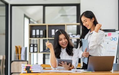 Two young businesswomen are delighted to be successful in online business. and had a huge income.