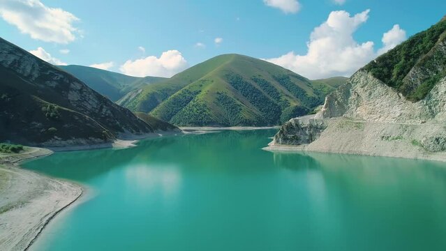 Aerial over lake Kezenoy-am with turquoise water and tall mountains around. Stunning scenery in highlands of Chechen Republic, Russia
