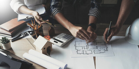 Team construction engineers working at construction site with blueprint on table