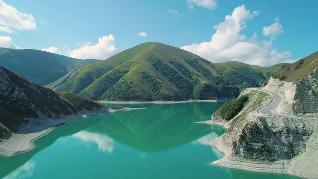 Aerial over lake Kezenoy-am with turquoise water and tall mountains around. Stunning scenery in highlands of Chechen Republic, Russia