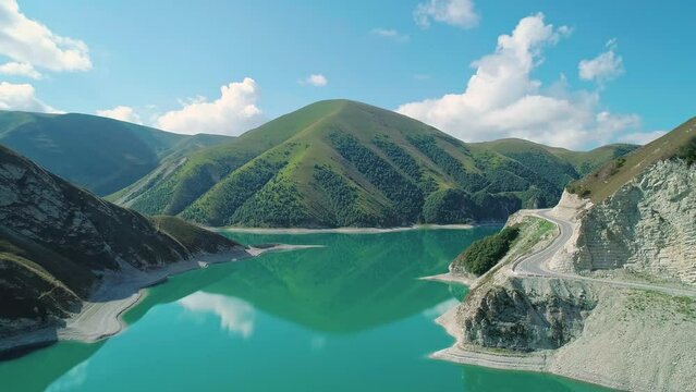 Aerial over lake Kezenoy-am with turquoise water and tall mountains around. Stunning scenery in highlands of Chechen Republic, Russia