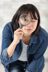 curious woman looking through a magnifying glass