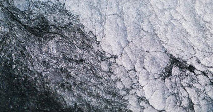 Frozen abstract background. Snow rock. Cold texture. Monochrome light white black ink glitter foam flow in water. Shot on RED Cinema camera.