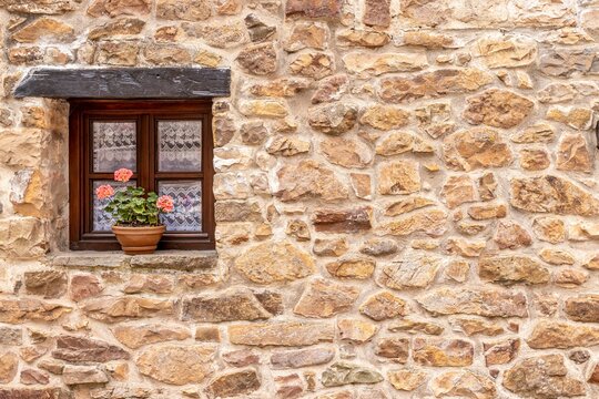 Picturesque stone house exterior wall with flowers in Barcena Mayor village in Spain