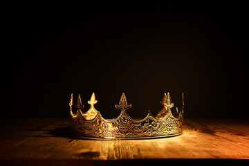 low key image of beautiful queen or king crown over wooden table. vintage filtered. fantasy...