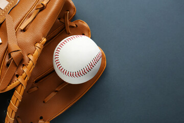 Catcher's mitt and baseball ball on dark background, top view with space for text. Sports game