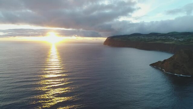 Sun is going down to the horizon and sun rays way shines on ocean water surface. Cinematic and unique sunset image from Azores islands Atlantic ocean.