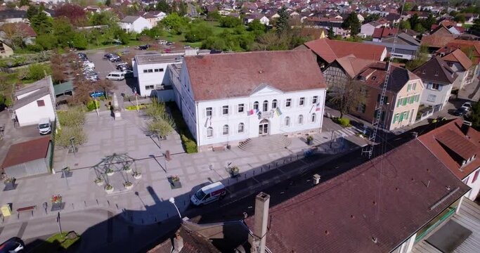 Drone aerial view of a town hall in Alsace, with a gendarmerie antenna in the foreground