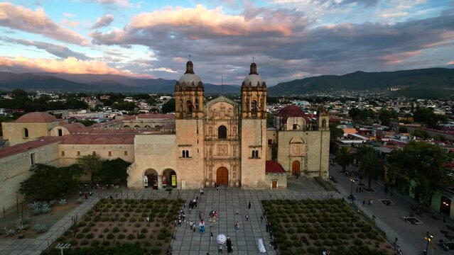 backwards drone shot of santo domingo temple world heritage site in oaxaca city mexico at sunset