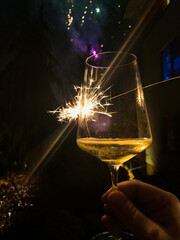 celebracja Nowego Roku kieliszkiem szampana na tle fajerwerków - obrazy, fototapety, plakaty