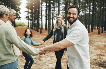 Happy family, hands and dance in forest with girl, parents and grandparents dancing in a circle in nature. Family, kids and holding hands with cheerful excited and laughing people in a park together