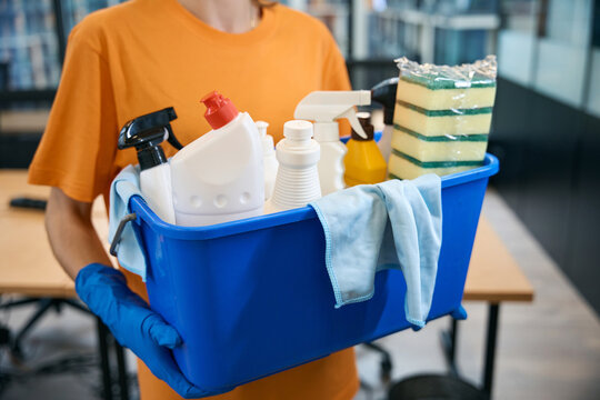 Cleaner cleaning company holds in her hands set of gadgets for cleaning
