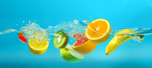 Fototapeta na wymiar Fruits mix splashing into clear water on turquoise blue background