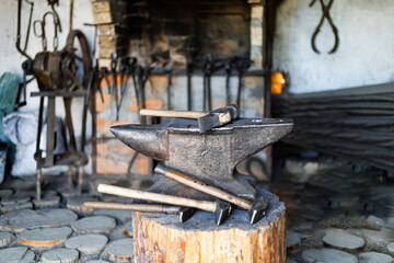 Fototapeta na wymiar Old anvil with iron hammers in a vintage forge.
