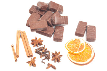 Chocolates with sliced dried orange,cloves,anise and cinnamon sticks top view. Concept of...