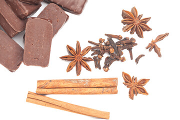 gourmet chocolate bonbons with anise and cinnamon sticks isolated on white background