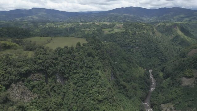 Aerial Drone Pan Above Magdalena River, Colombian Andean Valley, Cloudy Morning Flying The Green Deep Forest Vegetation