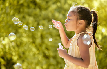 Bubbles, outdoor and girl in a nature park feeling relax, playful and content by sunshine. Child...