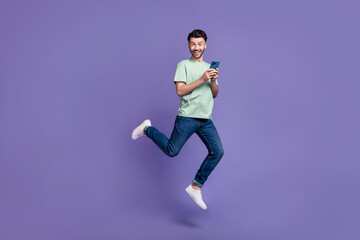 Fototapeta na wymiar Full length photo of positive cool man enjoy new quality gadget rejoice low price sale device shop isolated on purple color background