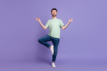 Fototapeta na wymiar Full length photo of concentrated positive man wear denim stand one foot leg enjoy hobby time isolated on purple color background