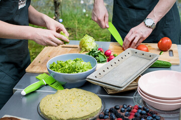 BBQ Outdoor with food preparations. People eating and dining outdoor. Lots of vegetables, fish, and meat.