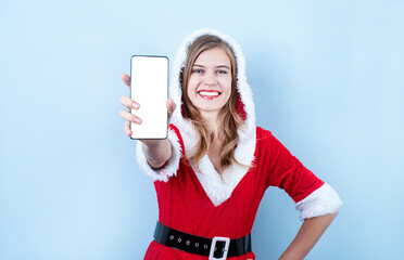 Naklejka premium closeup of caucasian happy woman wearing santa clothes pointing at the smartphone