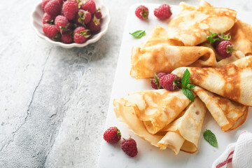 Pancakes. Stack of crepes or thin pancakes with berries, with raspberries and honey for breakfast. Pancake day is traditional american or english holiday concept. Homemade breakfast. Selective focus.