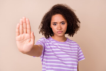 Photo of serious confident lady wear violet t-shirt rising arm showing no stop gesture isolated...