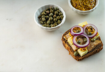 Scandinavian open sandwich with herrings on marble background. Copy space