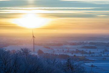 Wind turbines in a cold winter landscape at dusk