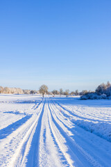 Obraz premium Snowy road with car tracks in the snow