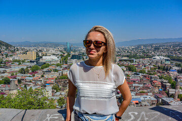 Tbilisi, Georgia-April 28, 2019: a young man on the background of a beautiful bird's-eye view of the Central part of Tbilisi.