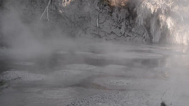 Static close-up shot of mud boiling and splashing with steam rising