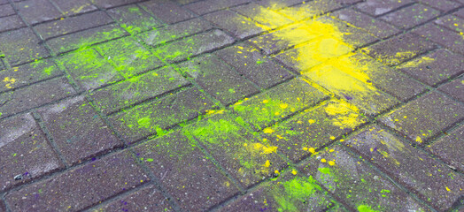 Multi-colored dry paints on paving slabs. Powder coating at the festival.