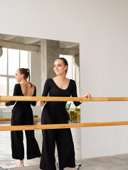 Modern female dancer in black outfit practices in a dance studio - 541452519