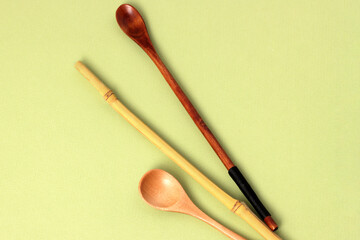 Eco bamboo spoon on green background. Concept organic cutlery, natural material, zero waste, eco-friendly. Flatlay