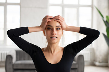 Young woman with hands on her head looking up, feeling stress and depression. Mental health problems concept