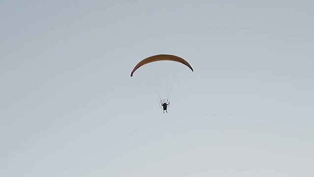 parapente volando sobre el cielo limpio y soleado, deporte extremo