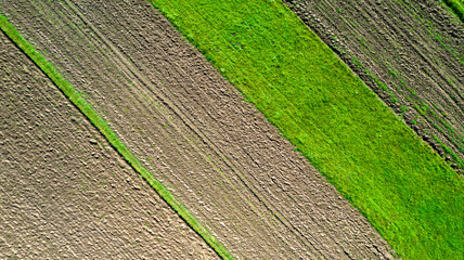 Agriculture background made by drone - green and soil aerial view