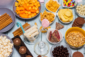 Salty and sweet snacks. Table of salty and sweet snacks. Large group of unhealthy food