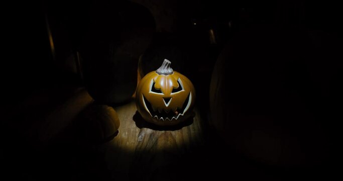 Halloween pumpkin in the dark vintage room, the spotlight from the left  alternative | camera in movement from dolly forward to the subject  | wide shot 4k 12-bit footage