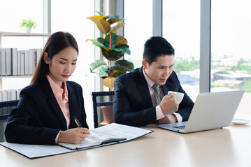 Asian businessman and secretary working together in the office. Teamwork concept.