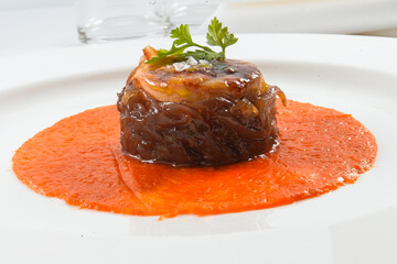 Atún rojo con cebolla confitada sobre salsa de tomate, recet gourmet. Red tuna with onion confit on tomato sauce, gourmet recipe. - obrazy, fototapety, plakaty