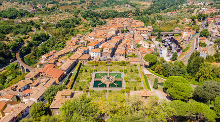 Fototapeta premium Panoramic aerial view of a small Italian town with square park, railway and bridge